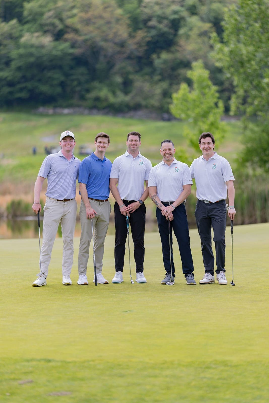 A foursome in Island Greens polos on the green at the Invitational